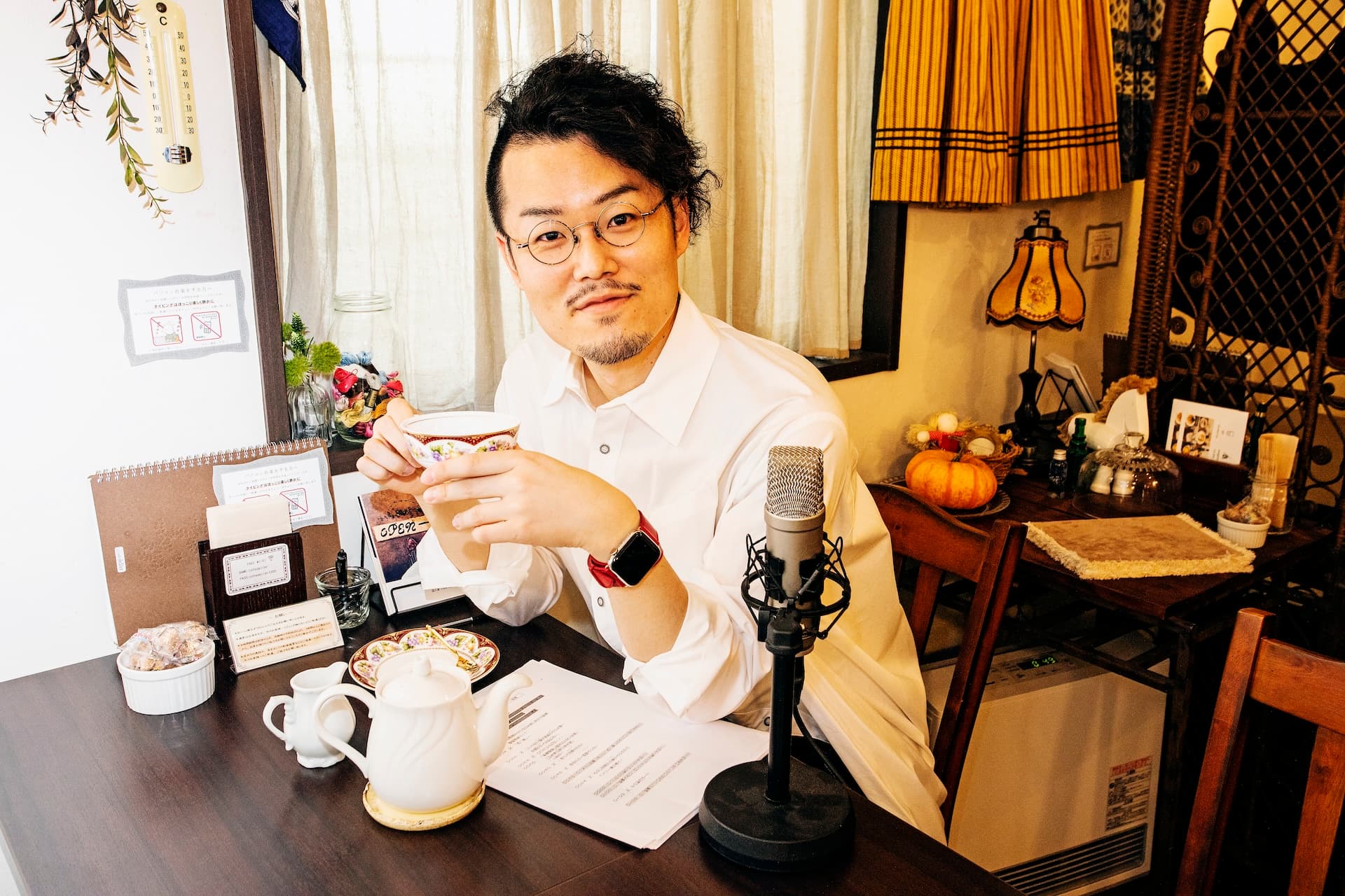 Kenta Suzuki with a teacup beside a studio microphone